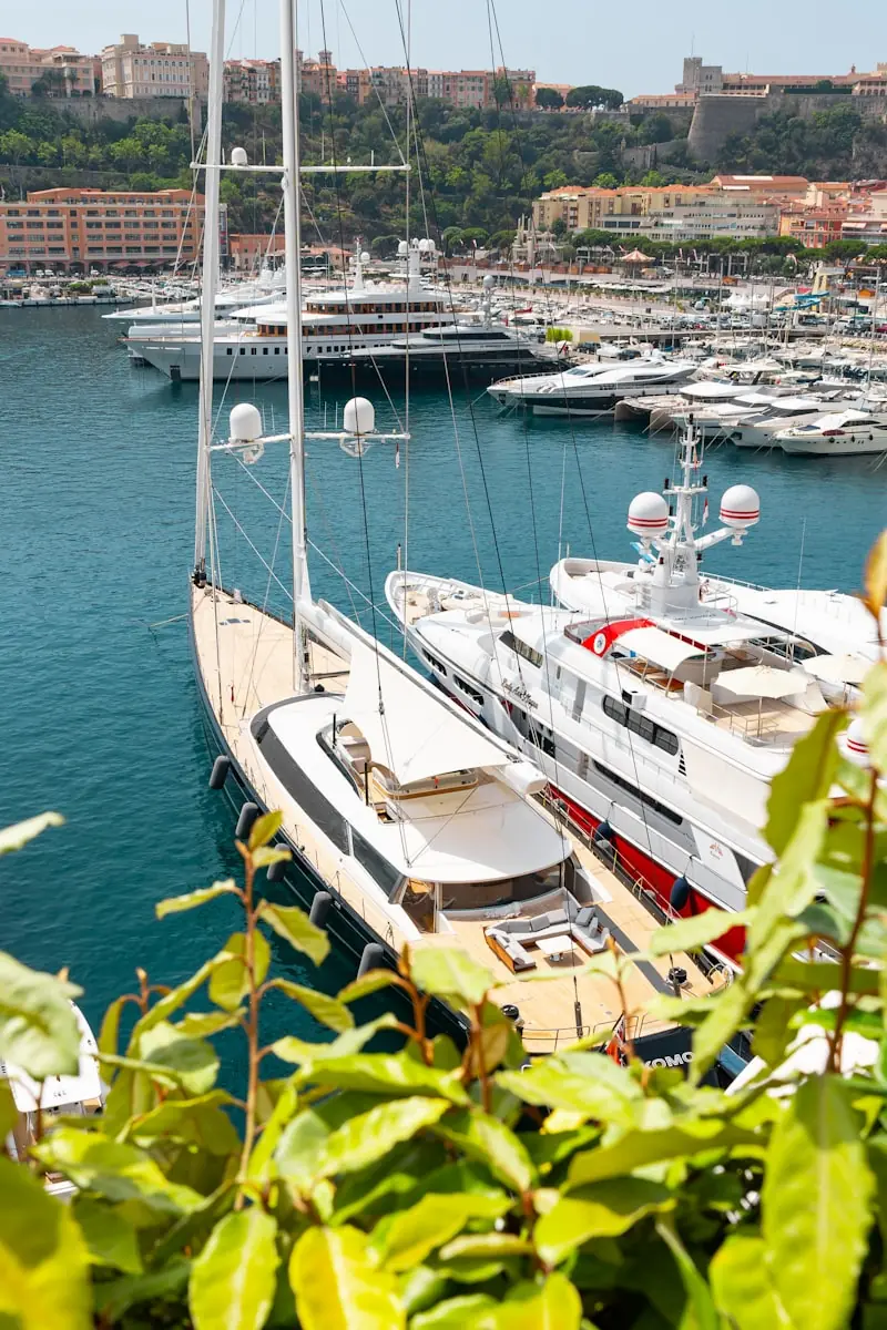 Private luxury yacht anchored in Monaco harbour at sunset with Monte Carlo skyline