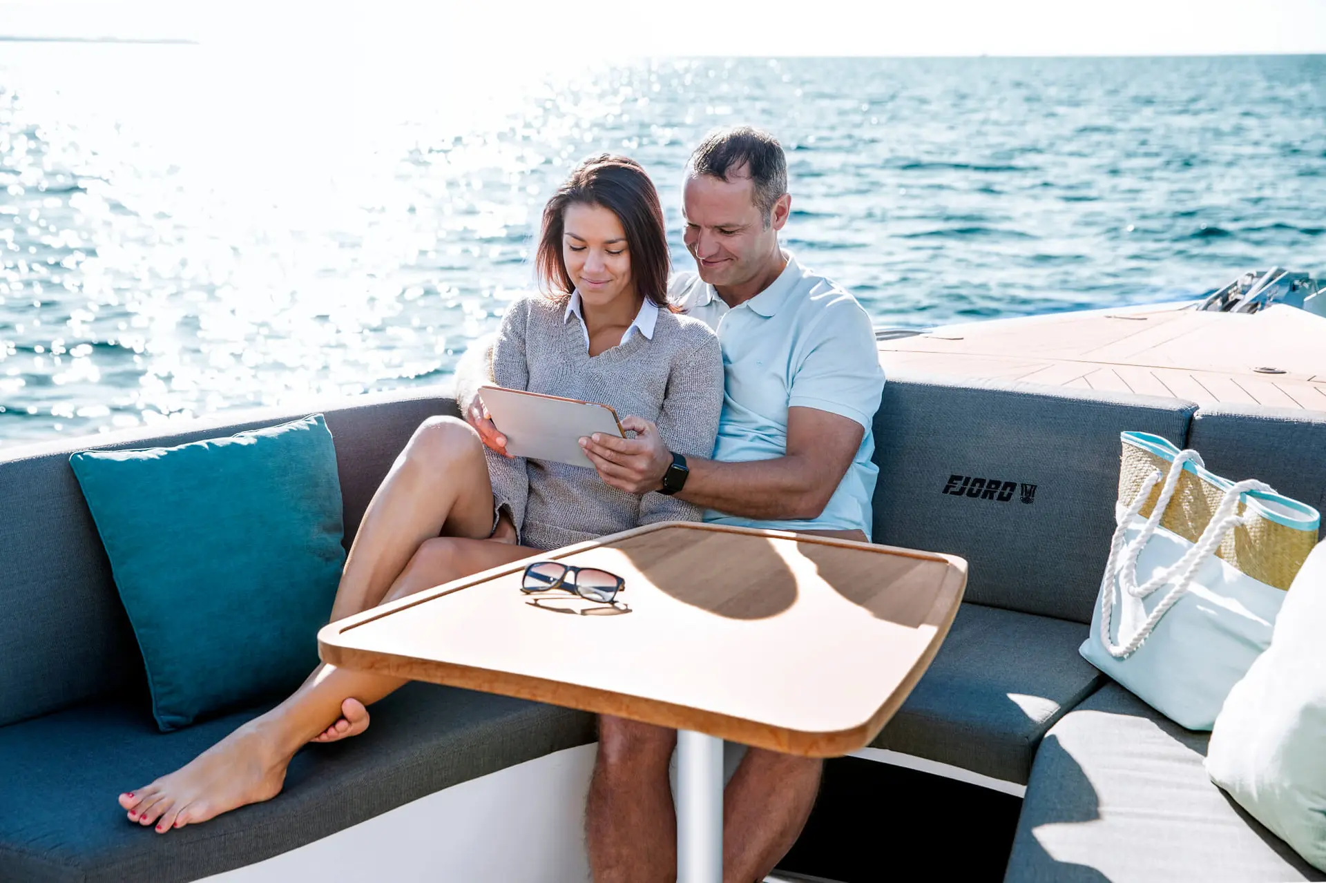 Couple browsing tablet in yacht cockpit lounge