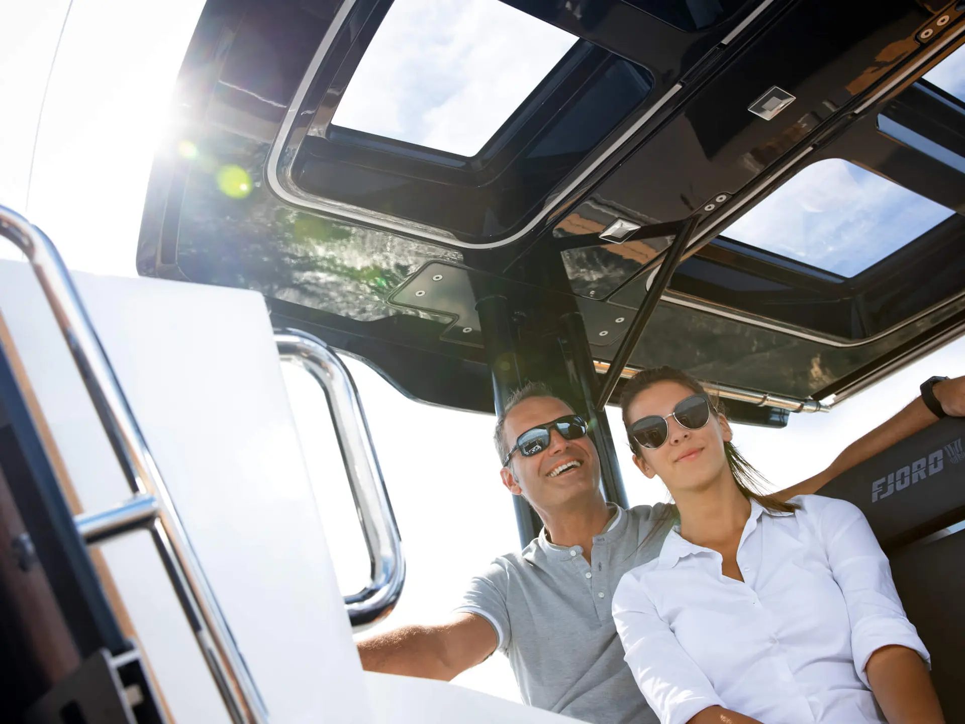 Couple at the helm of a Fjord day charter yacht