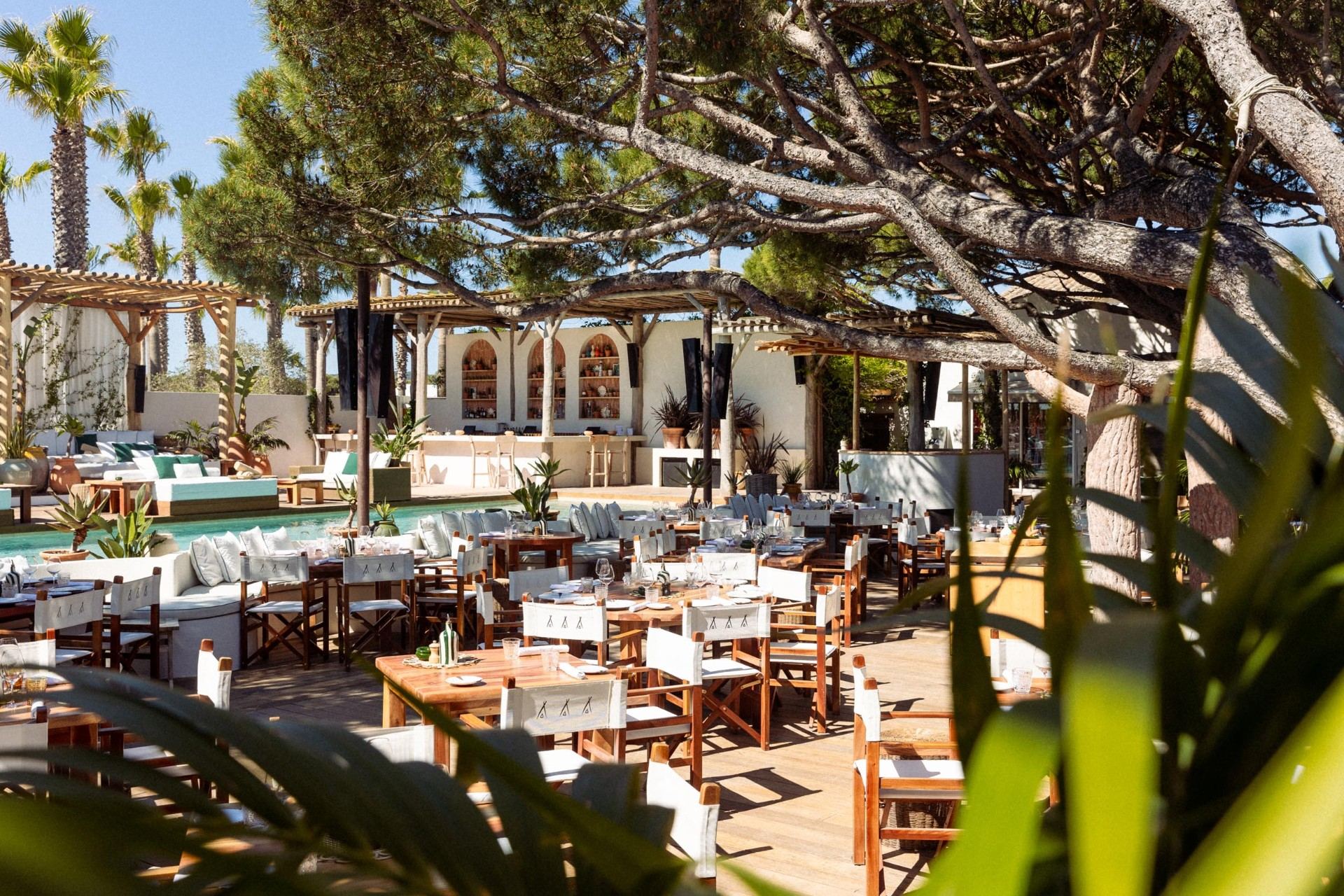 Riviera beach club restaurant with palm trees and poolside dining