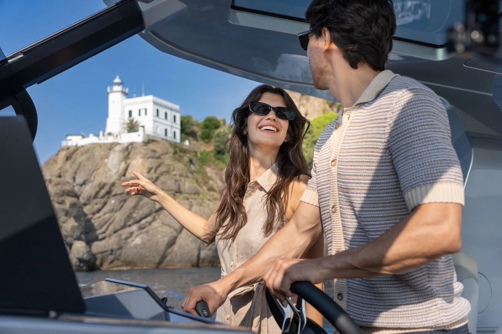 Couple at the helm of a Pardo day charter near lighthouse