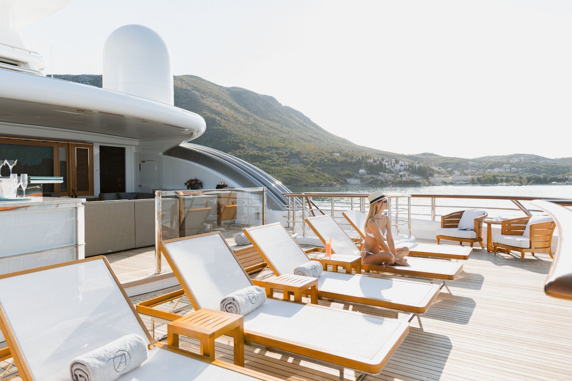 Woman relaxing on superyacht sundeck with loungers