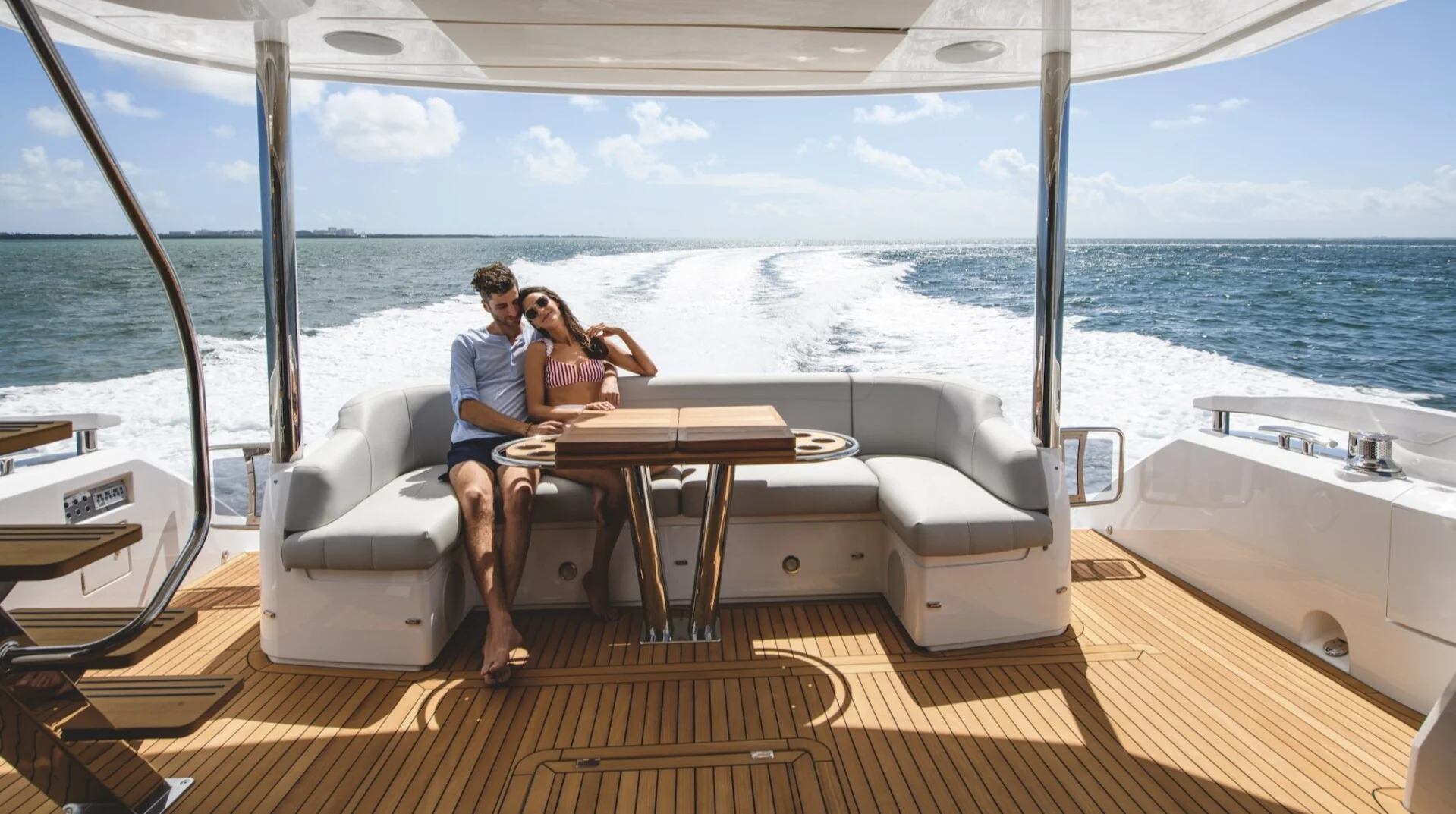 Couple relaxing on Sunseeker aft deck lounge while cruising