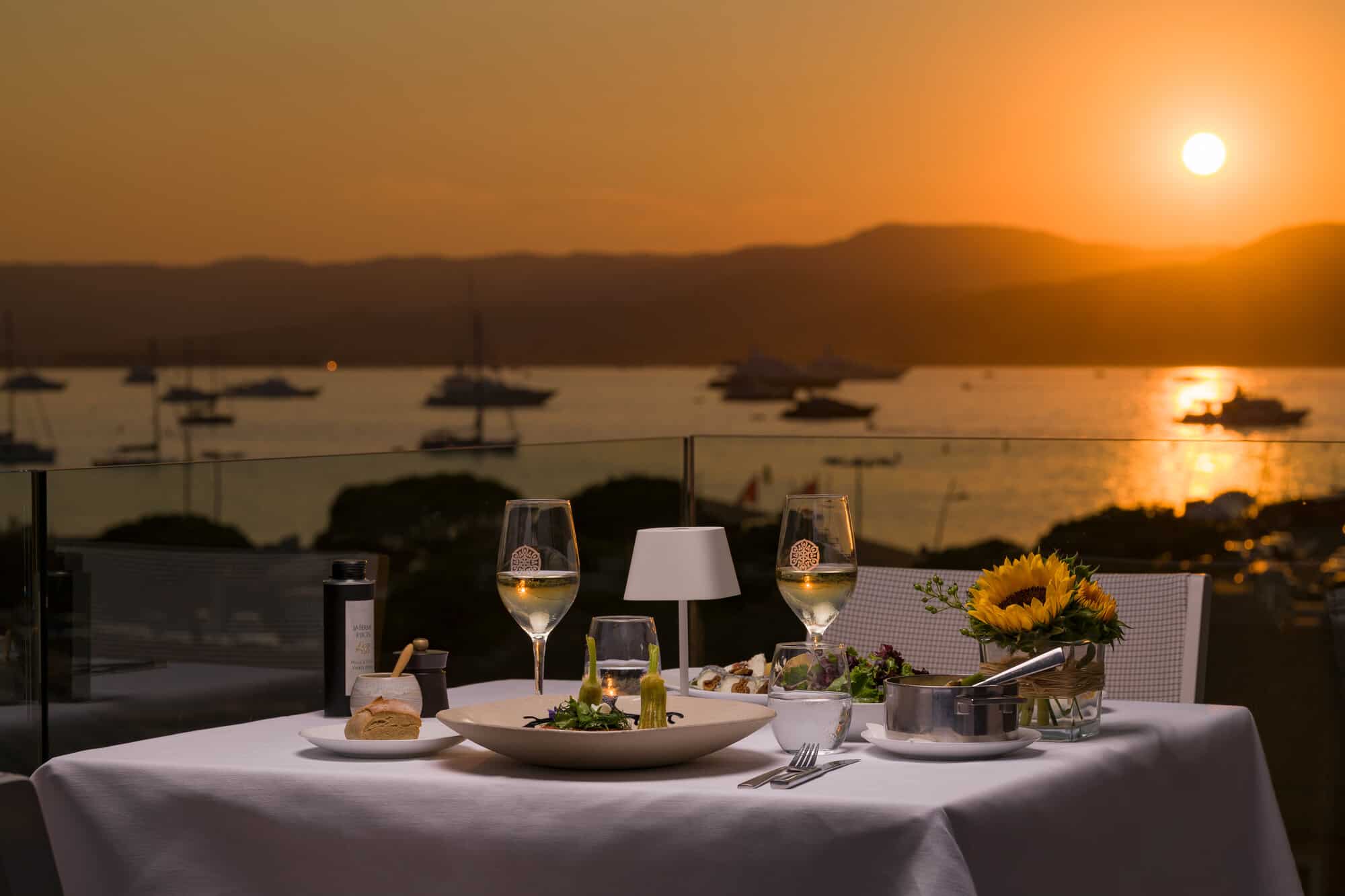 Romantic dinner table at sunset overlooking yacht harbour