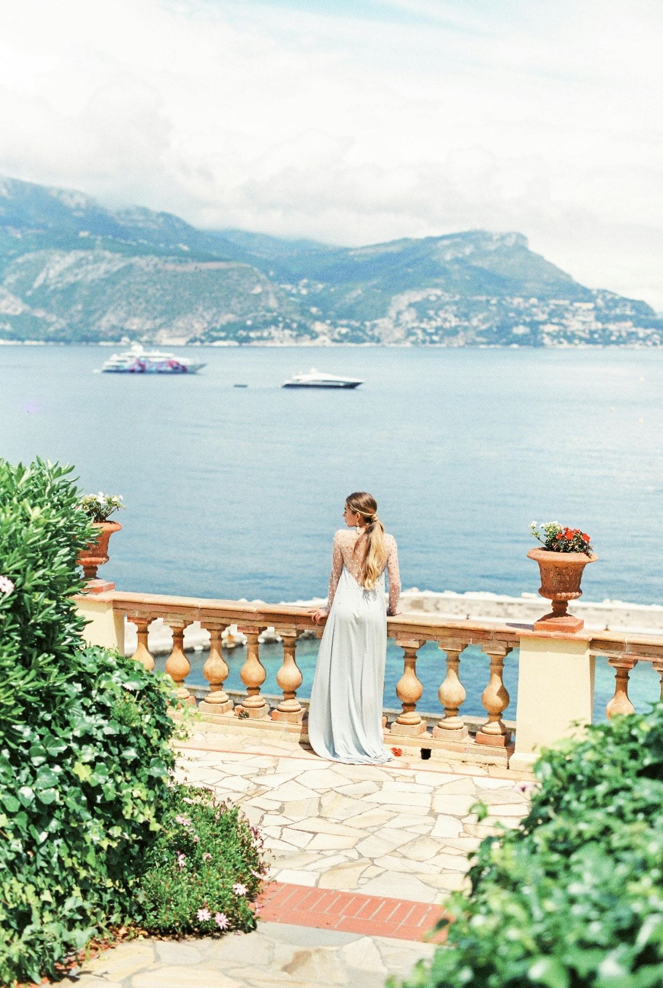 Woman on balcony overlooking the sea and yachts